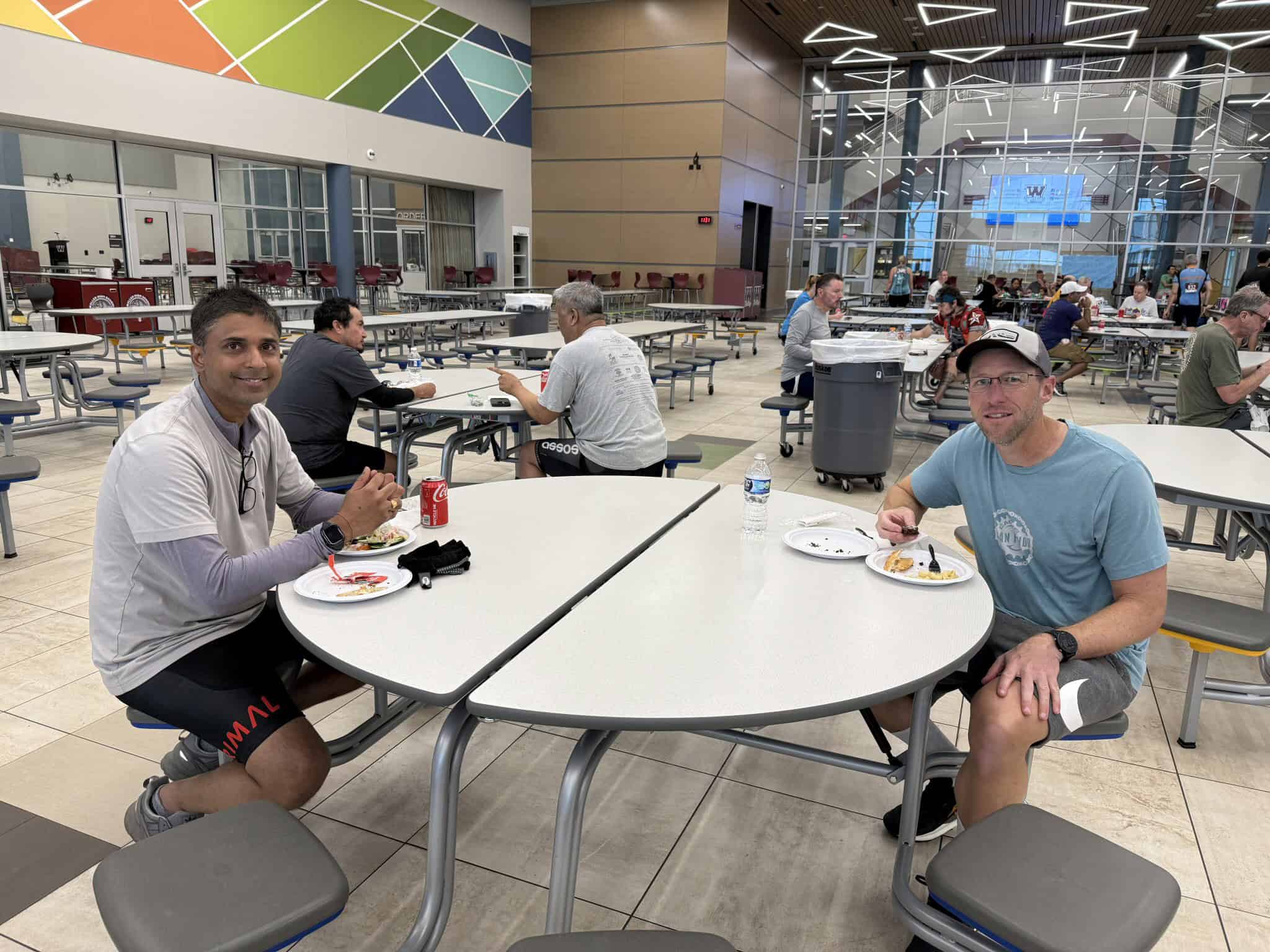 Bright indoor cafe with cyclists enjoying meals, modern lighting, and vibrant decor, part of Bluebonnet Express bike service.