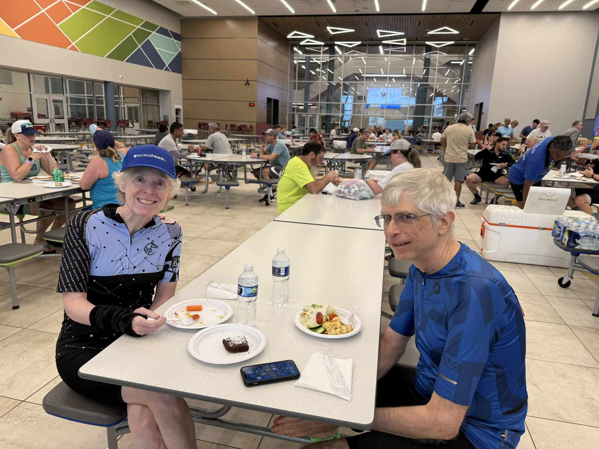 Enjoying a meal at the Bluebonnet Express in a busy, modern dining hall with cyclists and visitors.