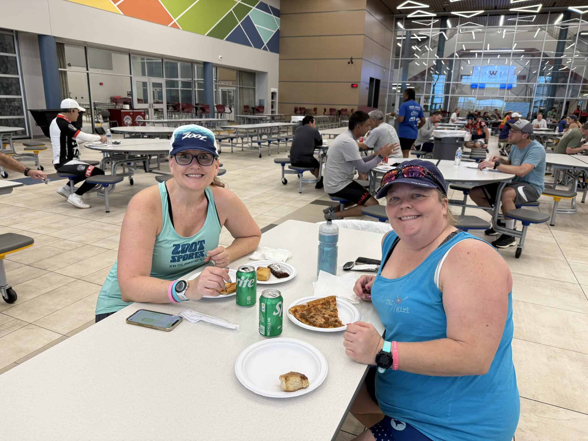 Friendly cyclists enjoying a meal after a Bluebonnet Express ride at a spacious indoor dining area.