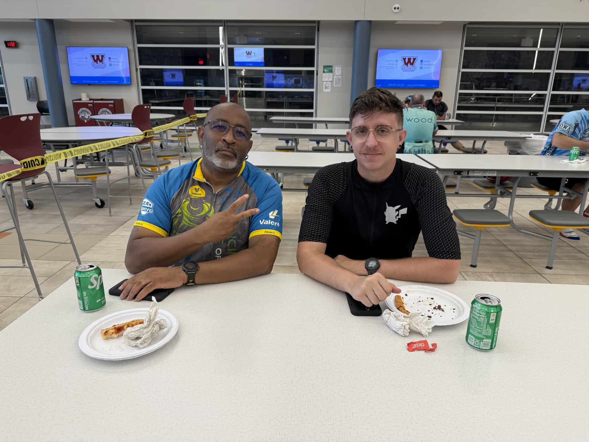 High school students enjoying pizza and soda at Bluebonnet Express event in school cafeteria.