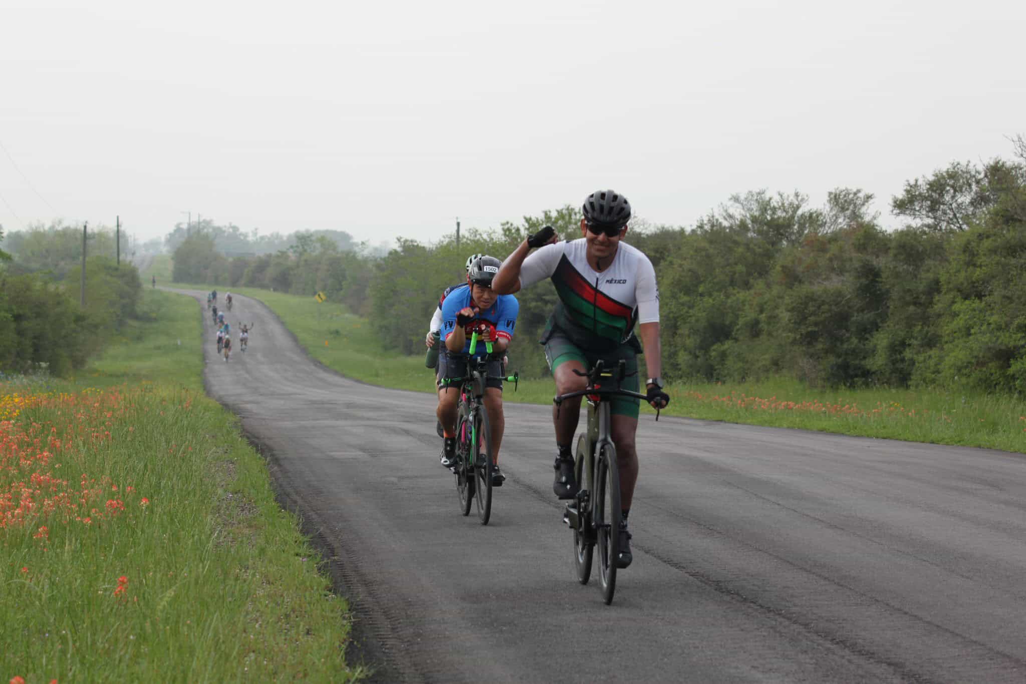 Vibrant group cycling on scenic rural road during Bluebonnet Express event, promoting outdoor fitness and community engagement.
