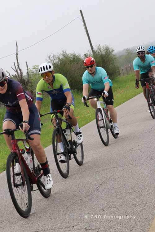 Cycling race group on scenic rural road during daytime, Bluebonnet Express event.
