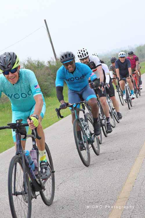 Cyclists riding together on a scenic rural road during Bluebonnet Express event.