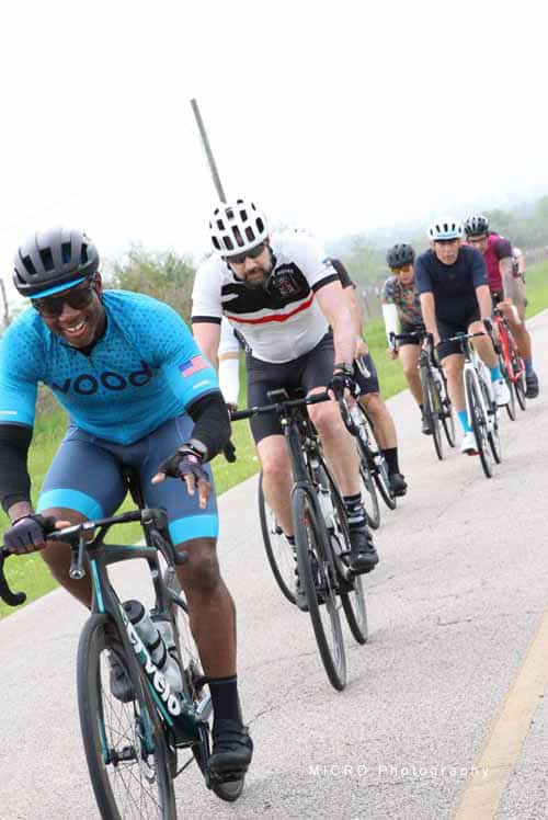 Vibrant group of cyclists riding together on a scenic outdoor trail for Bluebonnet Express event.