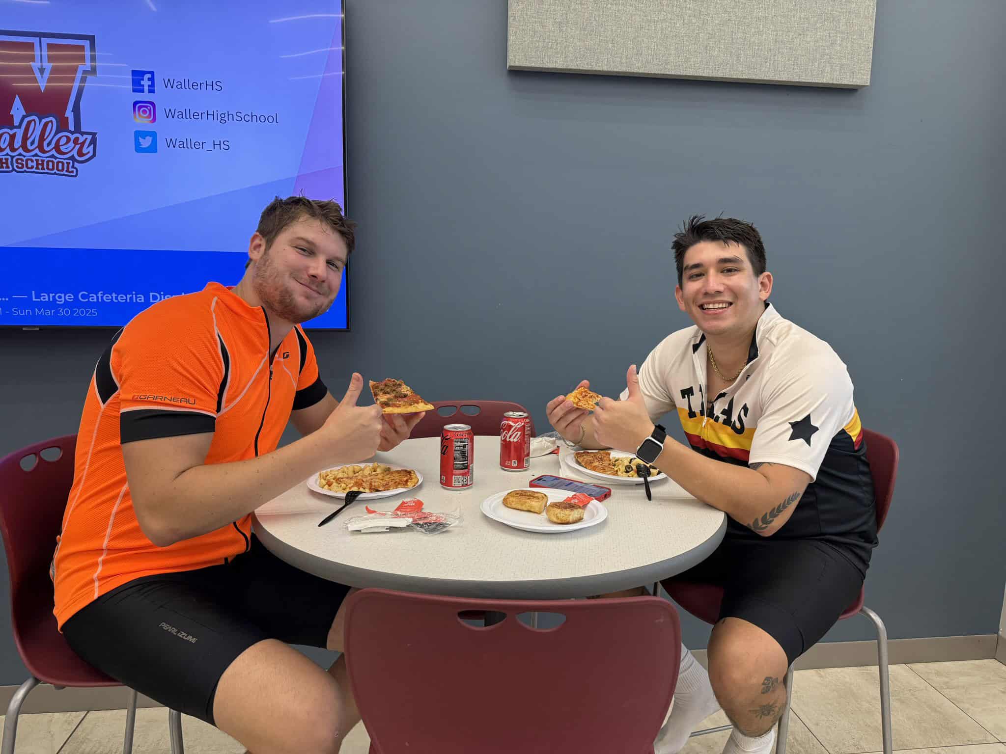 Cheerful cyclists enjoying pizza at Bluebonnet Express, a popular stop for bikers in Texas.