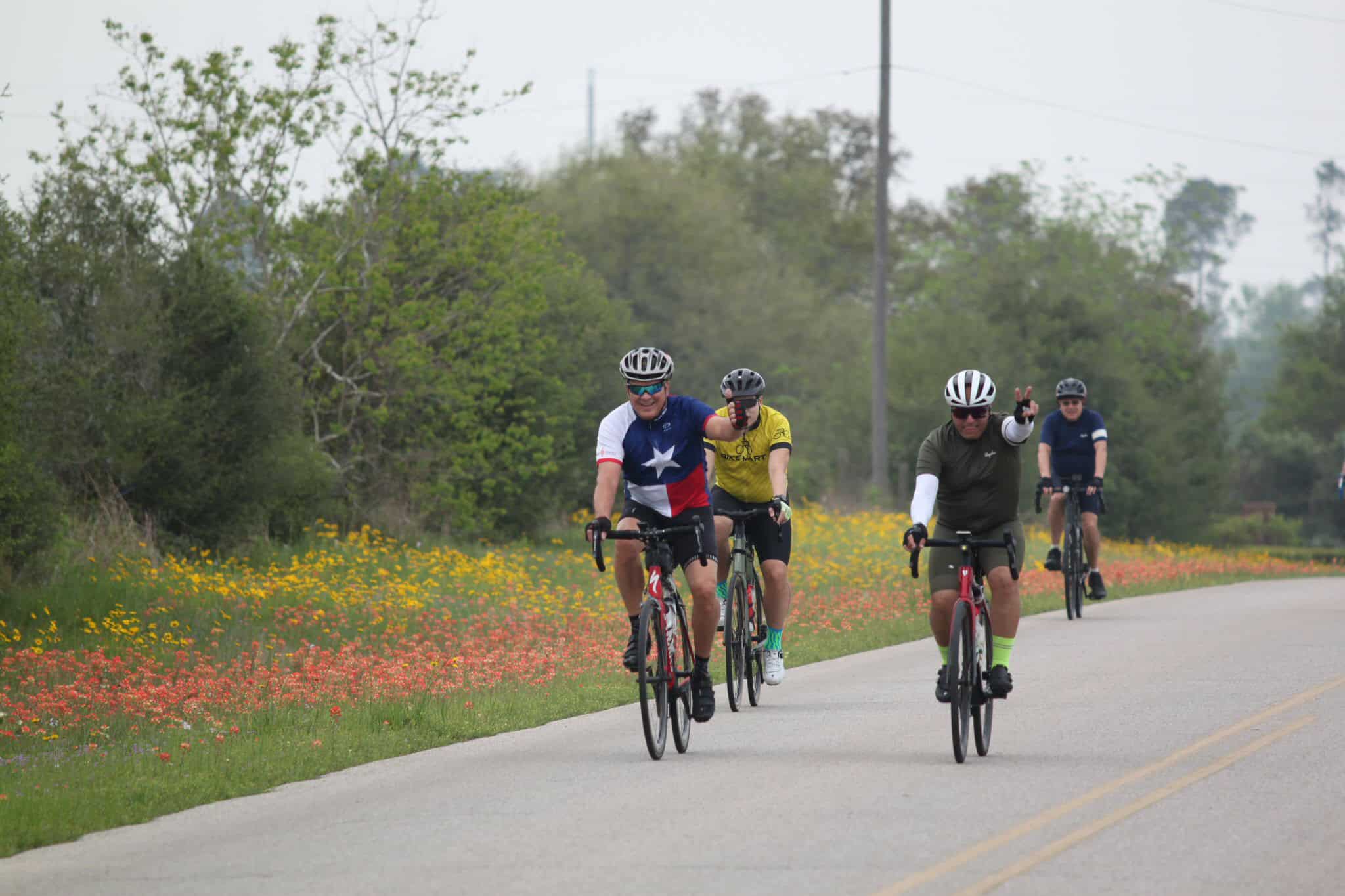 Bright cyclists riding on a scenic road during Bluebonnet Express bike event in Texas.