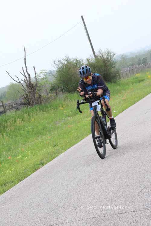 High-performance cyclist riding on a paved trail in nature, promoting health and eco-friendly transportation.