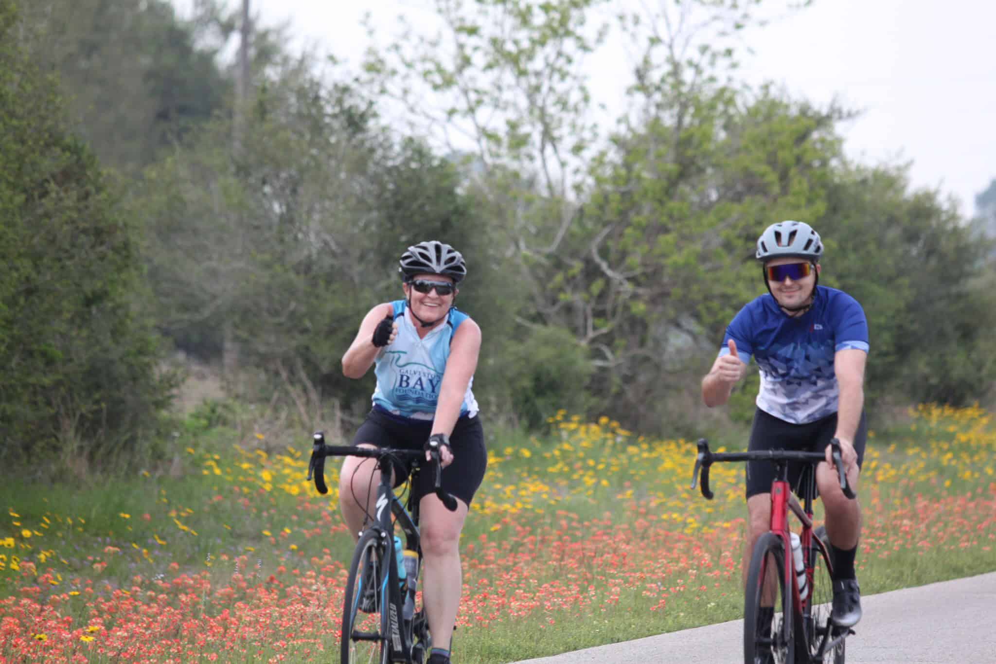 Enjoying scenic cycling on the Bluebonnet Express trail in Texas, surrounded by vibrant wildflowers and lush greenery.