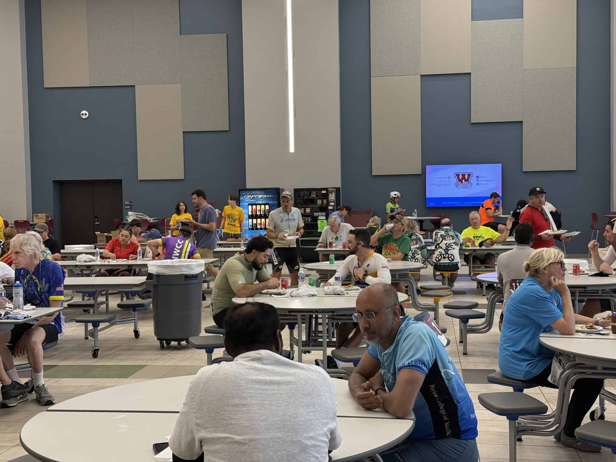 Colorful indoor dining area during a community event at Bluebonnet Express with diverse attendees.