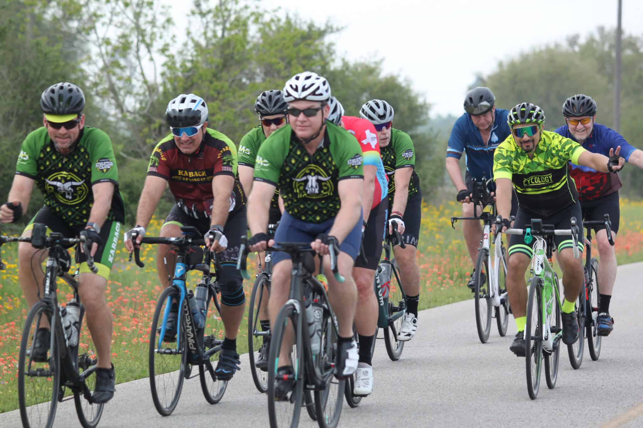 Vibrant group cyclists riding on a scenic trail during daylight, showcasing the Bluebonnet Express event.
