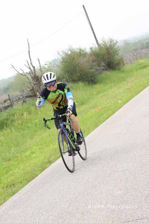 Bright young cyclist riding on scenic rural trail in Bluebonnet Express event.