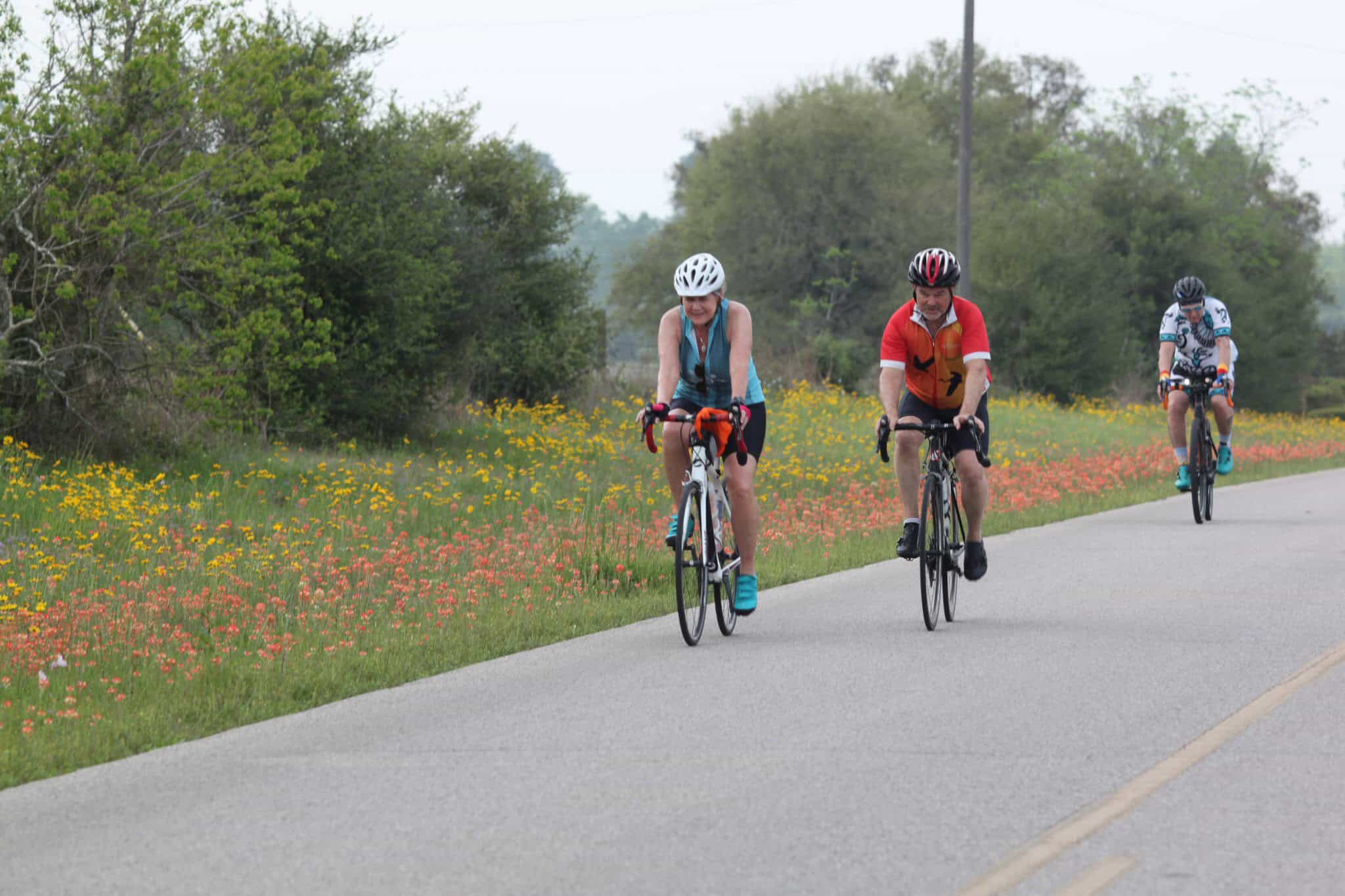 Enjoying outdoor cycling adventure on a scenic Texas countryside road with colorful wildflowers.