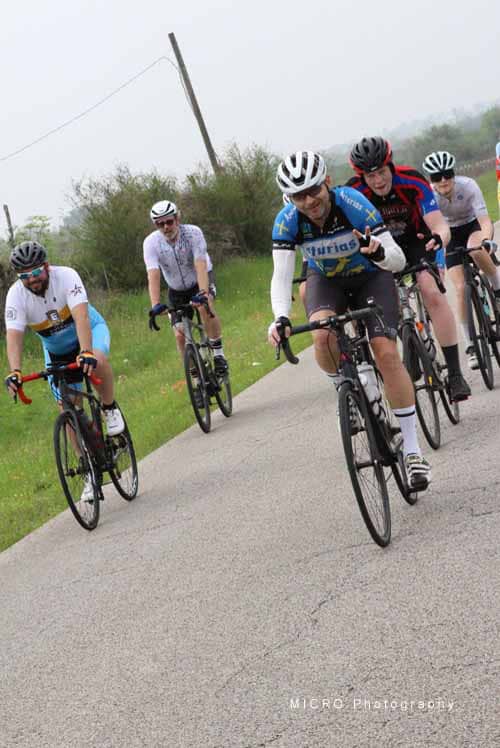 Cyclists riding in a group during the Bluebonnet Express cycling event on a rural road in Texas.