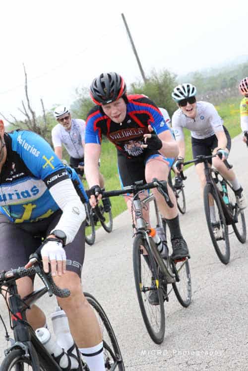 High-performance cycling race with Bluebonnet Express cyclists on a paved road.