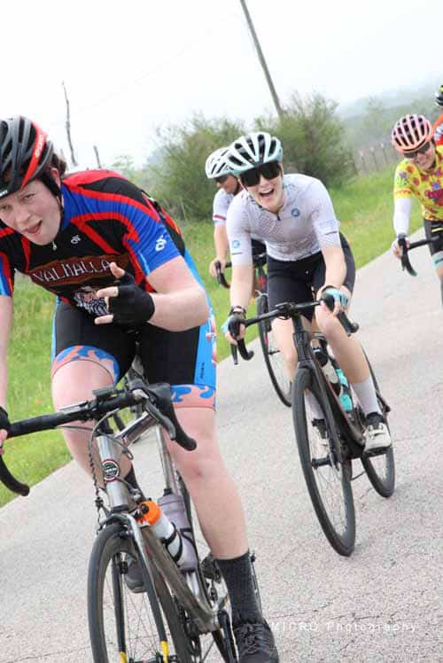 Energetic cyclists riding on a scenic route during Bluebonnet Express event.