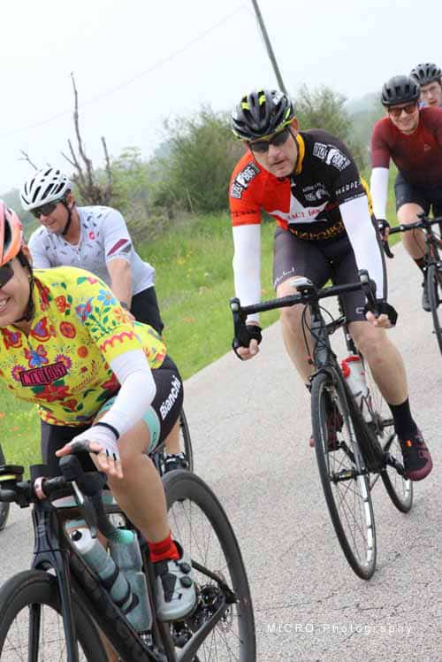 Bright-eyed cyclists riding through scenic countryside on the Bluebonnet Express cycling route.