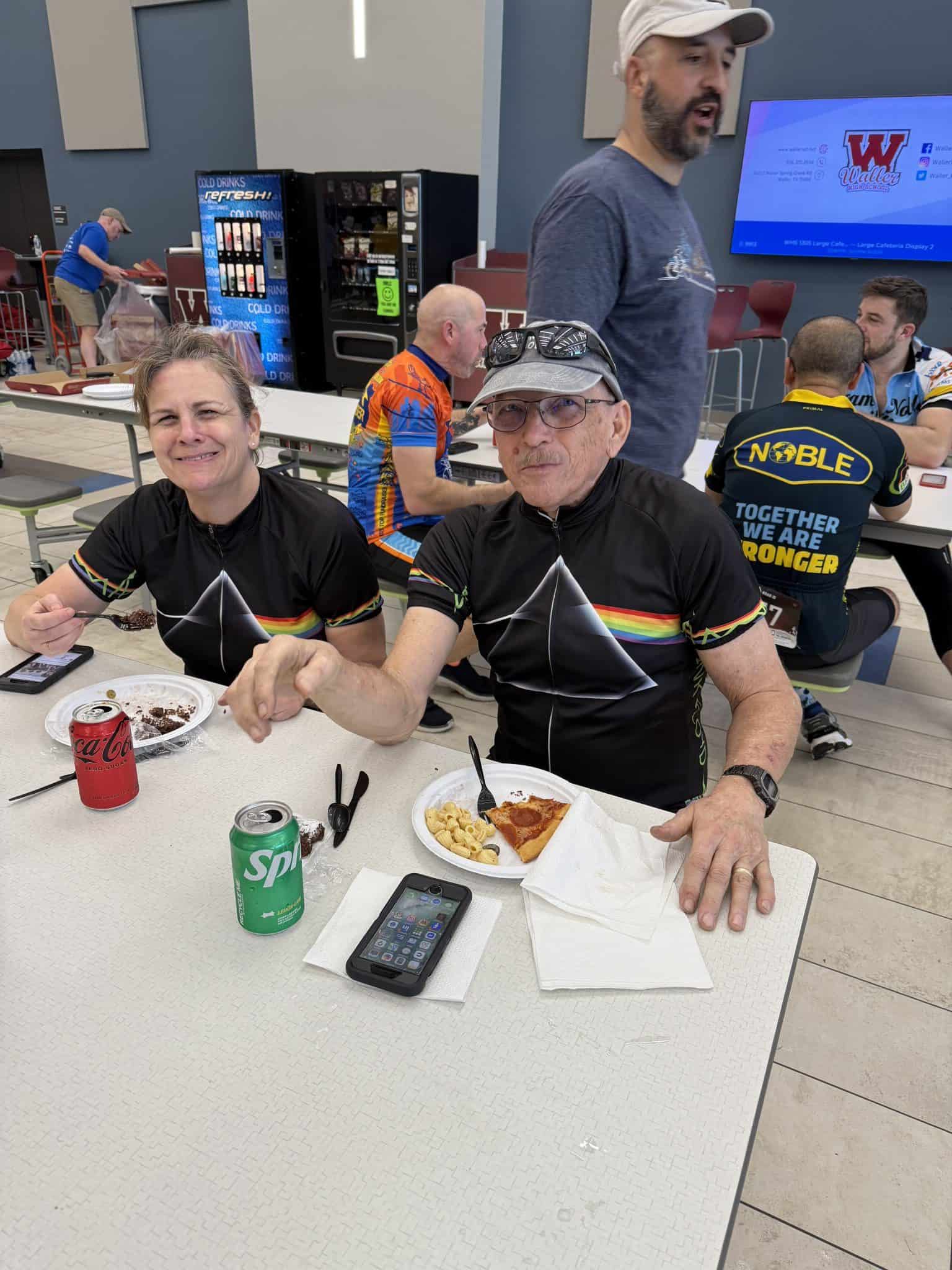Enjoying a break with pizza and drinks at Bluebonnet Express, a popular spot for cyclists and travelers.