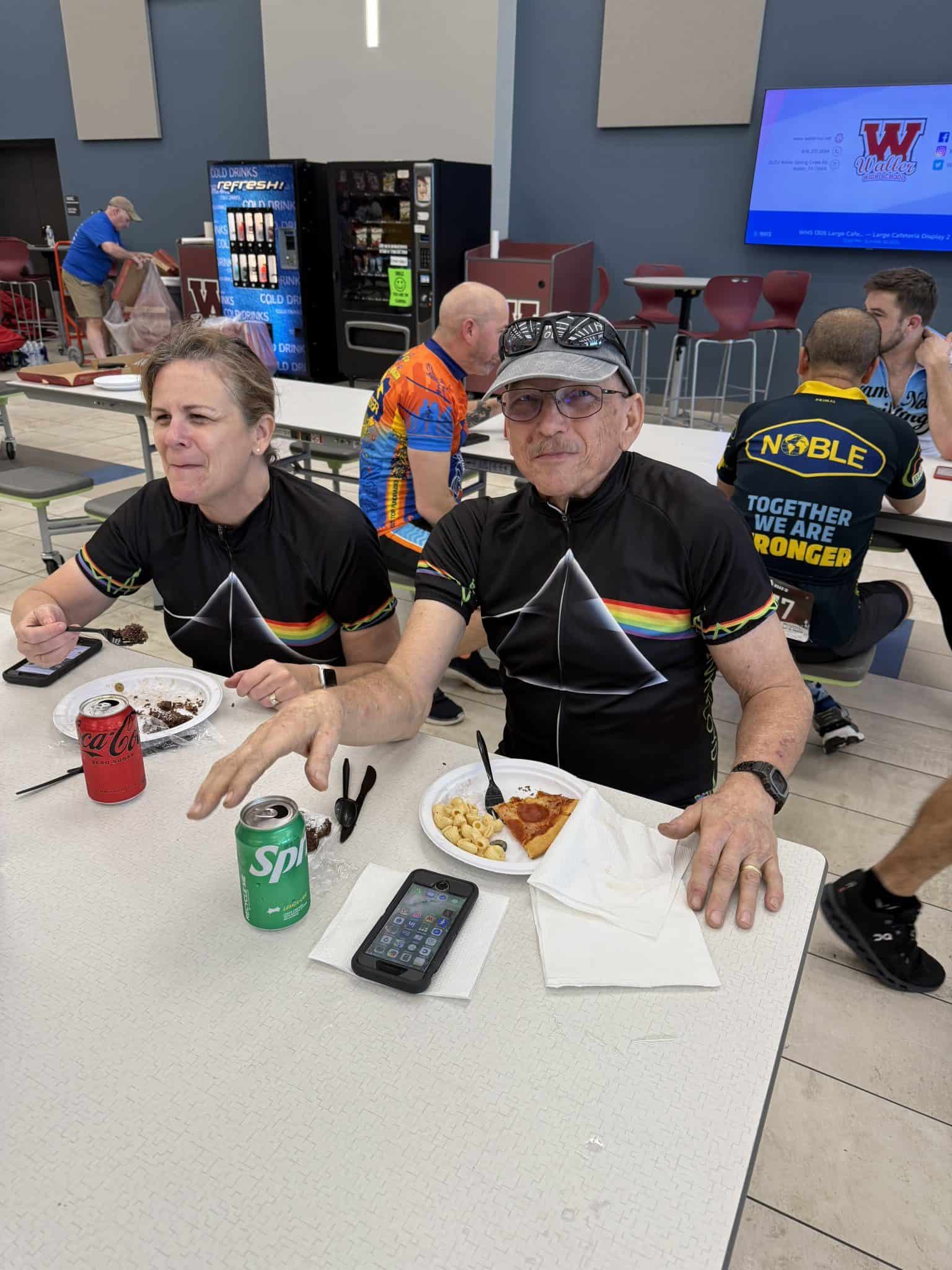1. Male and female cyclists enjoying a break at Bluebonnet Express in a dining area.