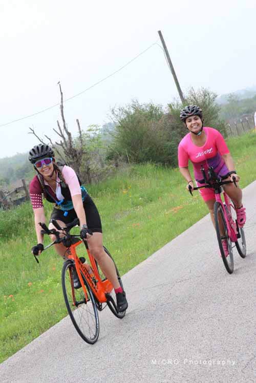 Bright female cyclists riding bikes on a scenic outdoor trail, promoting fitness and adventure.