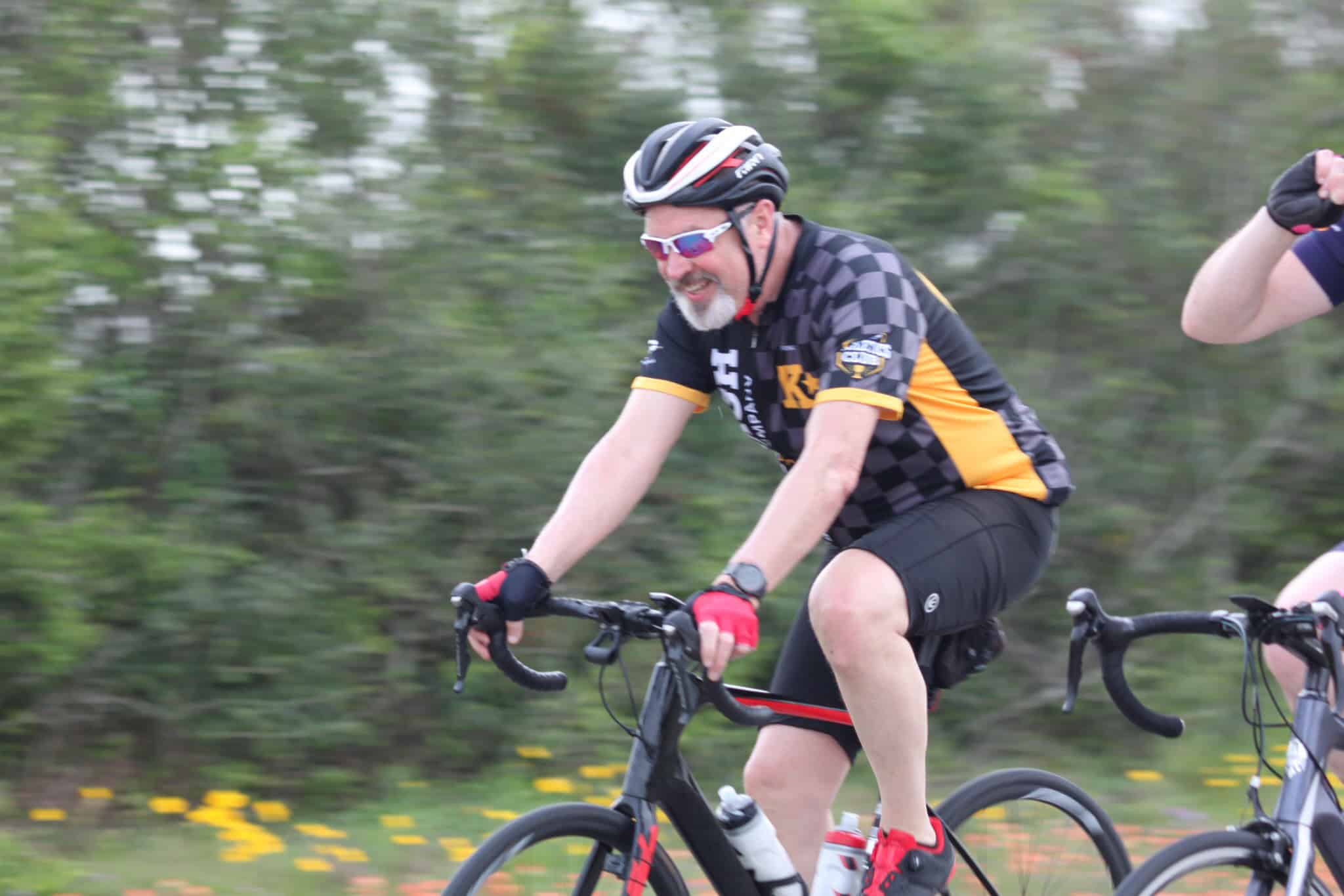 Active cyclist riding on the Bluebonnet Express bike trail during daytime.