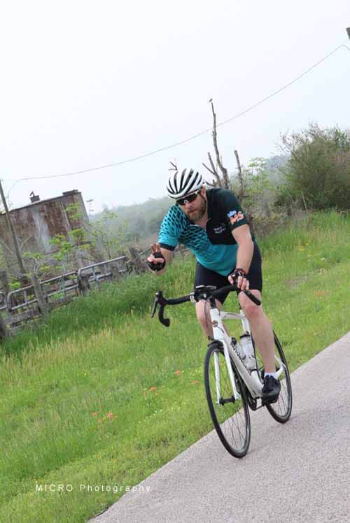 1. Man riding a road bike on a scenic countryside trail during daytime.