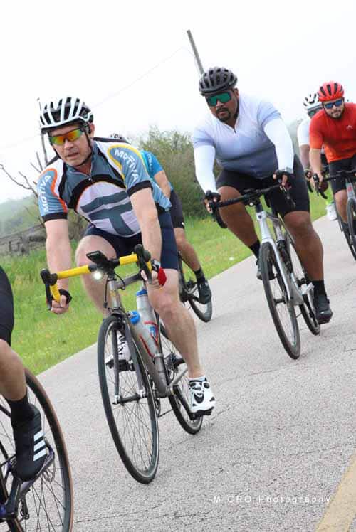 Brightly Colored Cycling Group Riding on Open Road During Bluebonnet Express Ride.