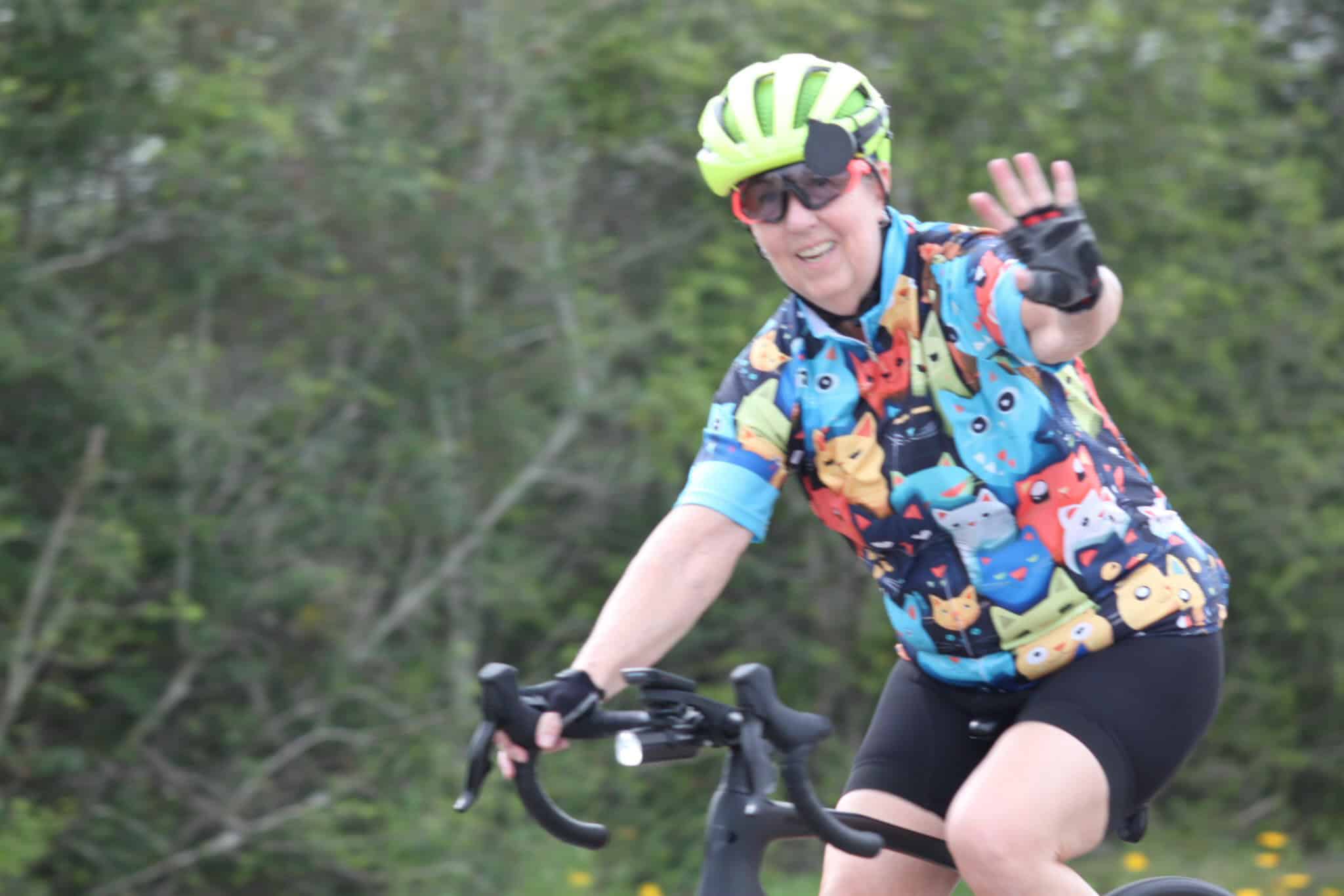 Colorful cycling jersey with Pokémon print on a woman riding a bike outdoors.