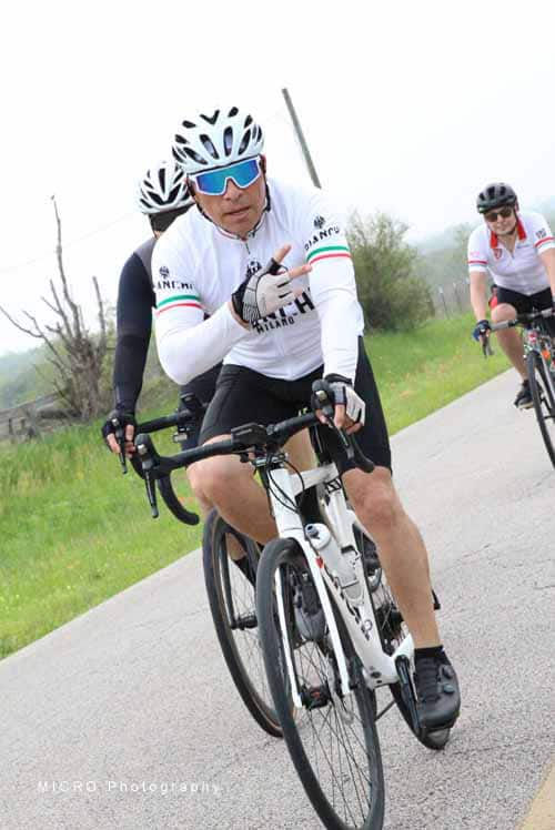 1. Cyclist wearing White jersey and helmet on scenic road during Bluebonnet Express ride.
