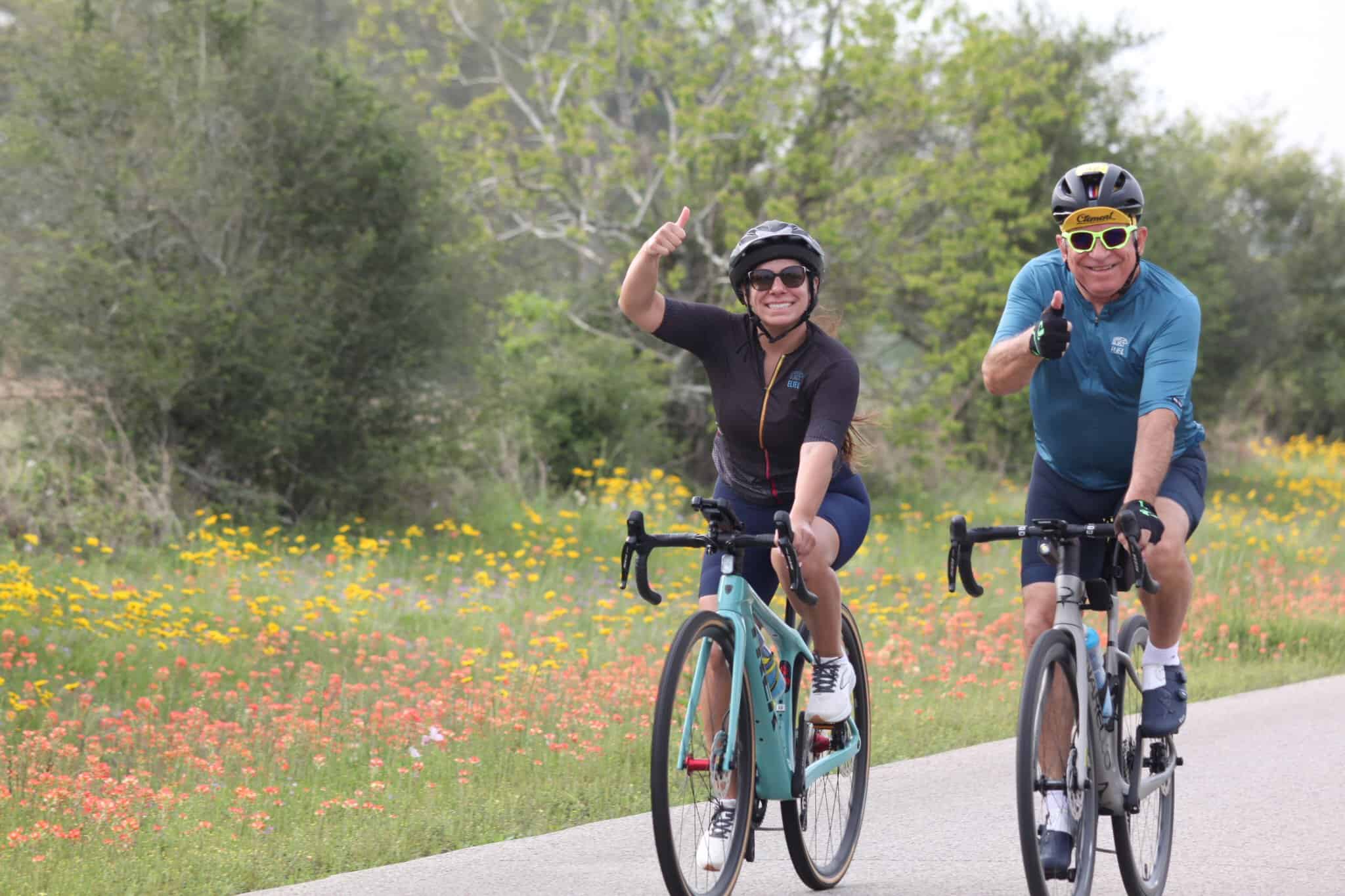 Vibrant cyclists enjoying outdoor biking amidst colorful wildflowers on scenic trail.