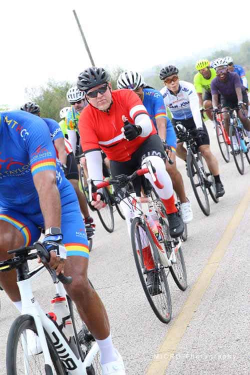 Cycling team participating in Bluebonnet Express race on open road.