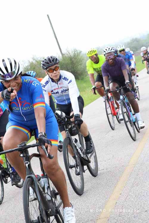 Colorful cyclists riding together during Bluebonnet Express charity bike ride event.