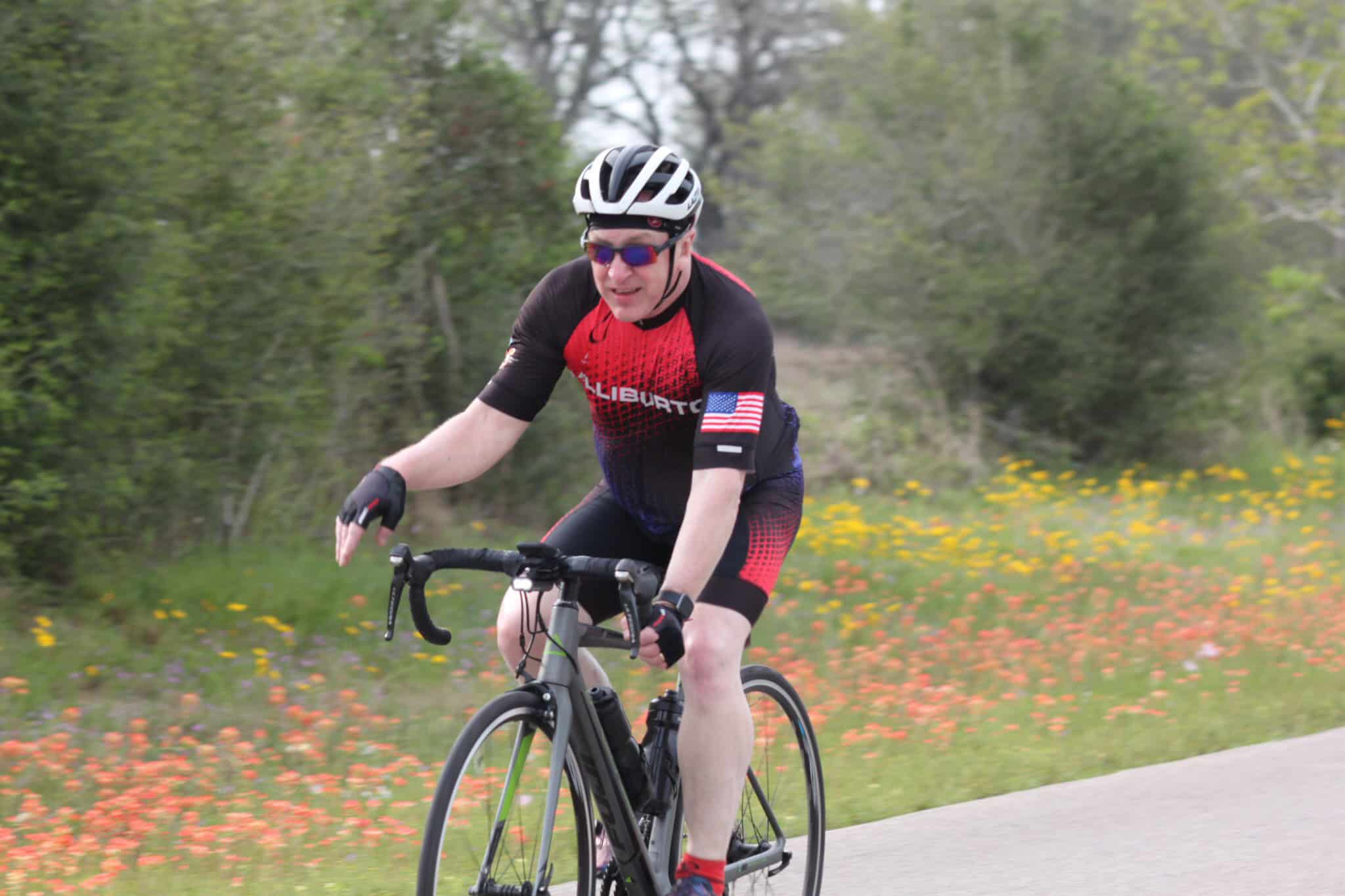 Vibrant cyclist riding a road bike on scenic trail during daytime.