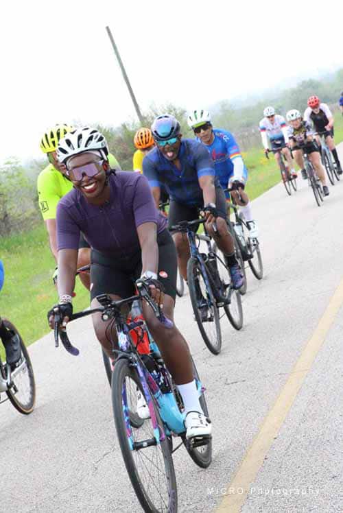 Vibrant group of cyclists participating in Bluebonnet Express charity ride on scenic countryside road.