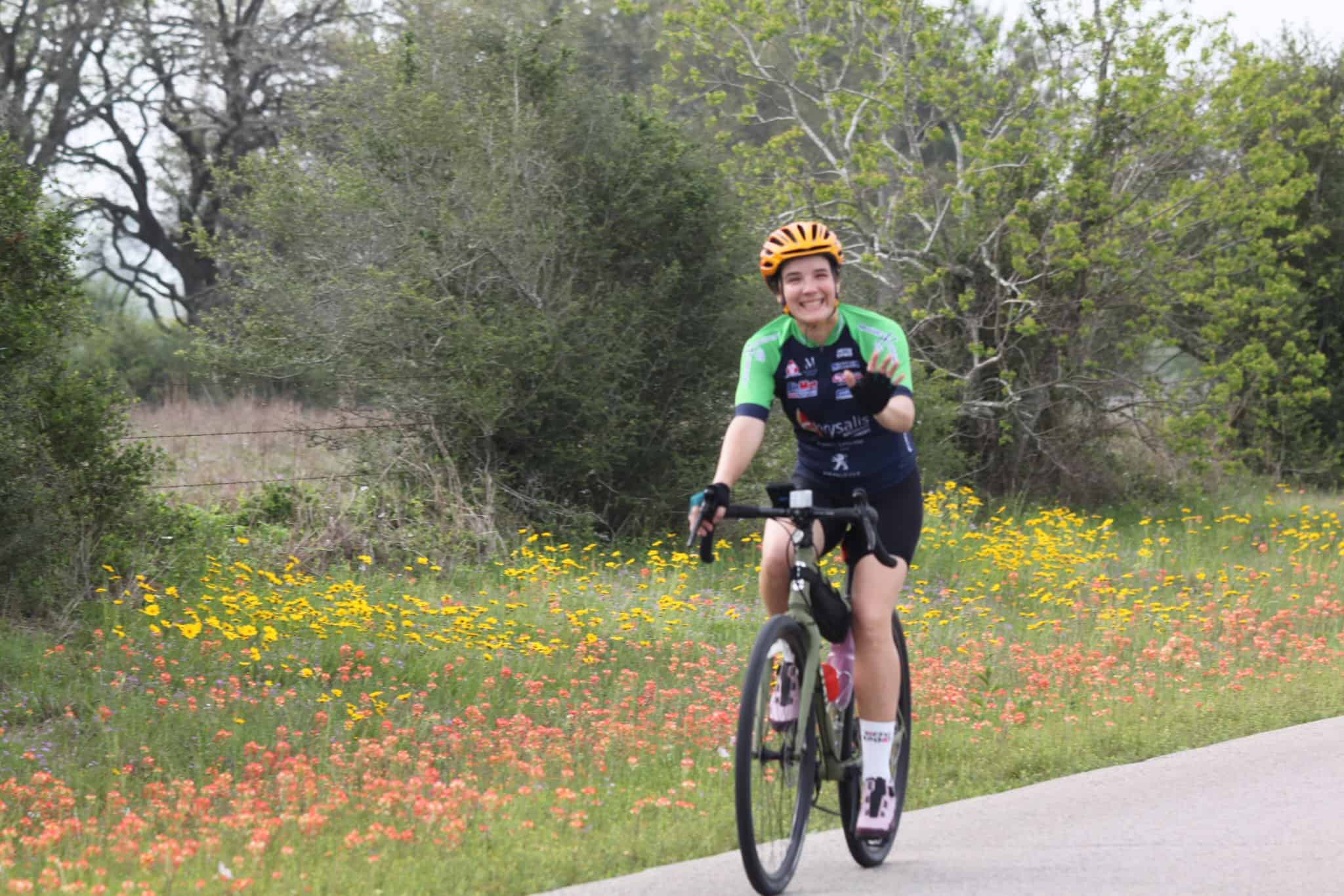 Vibrant cyclist enjoying scenic bike ride with wildflowers during Bluebonnet Express event.