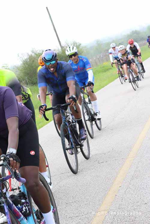 Cyclists riding during Bluebonnet Express event on scenic rural road for bike enthusiasts and community riders.