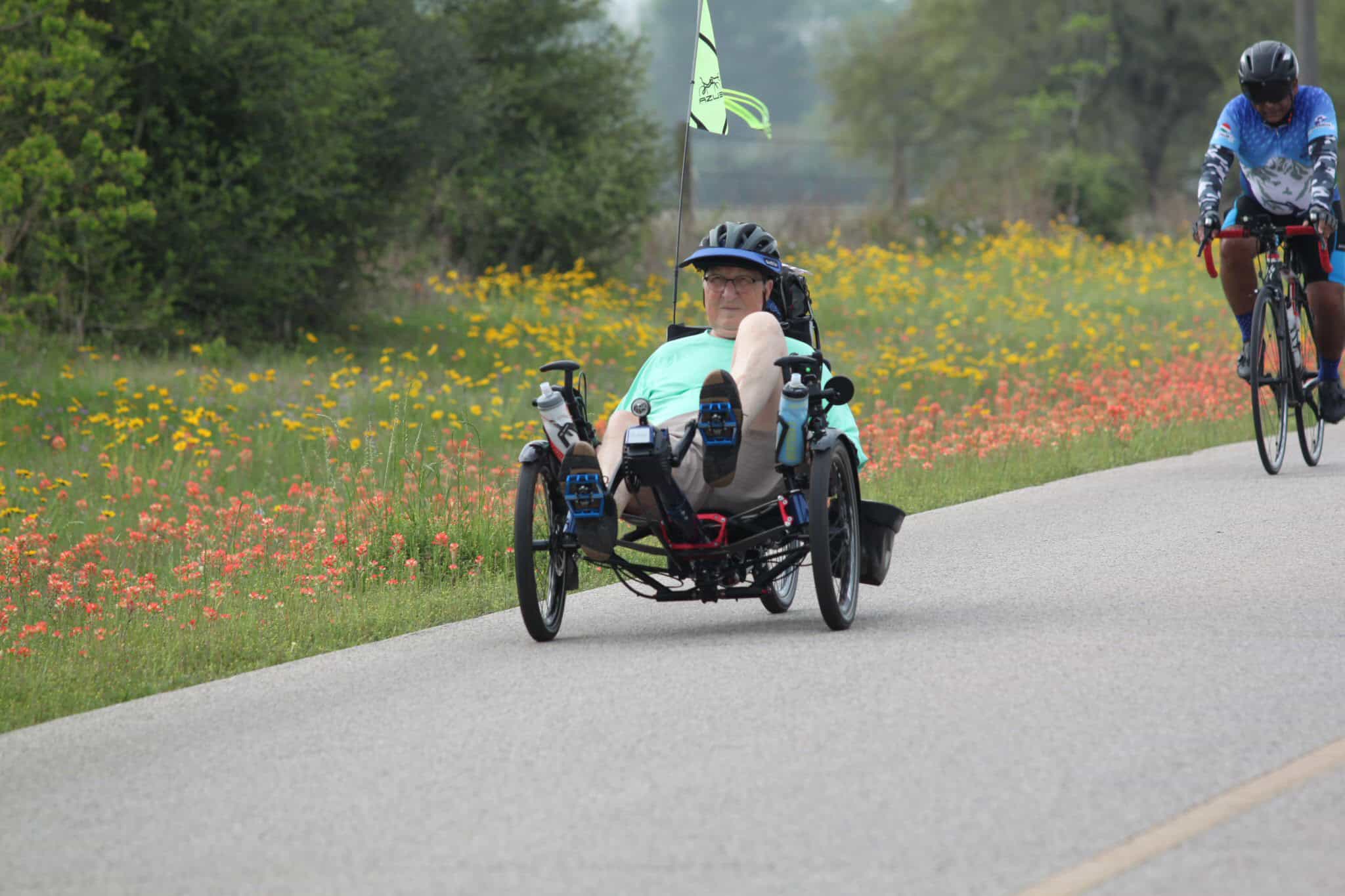Handcycle rider participating in the Bluebonnet Express bike event on a scenic trail.