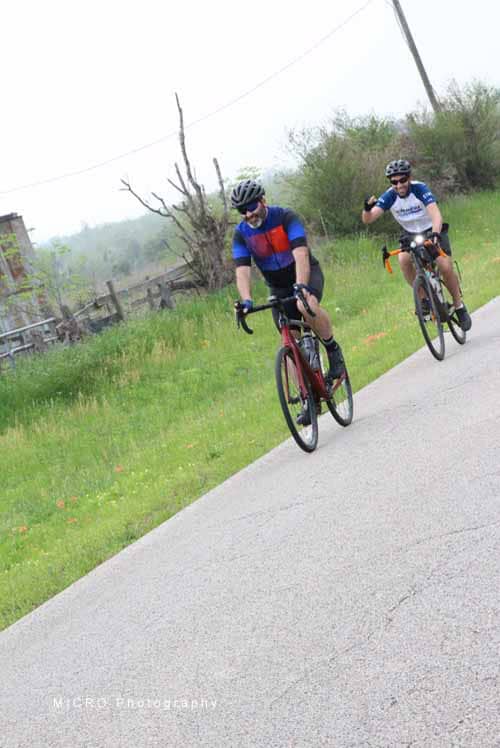 Riders on Bluebonnet Express trail enjoying scenic cycling ride in nature environment.