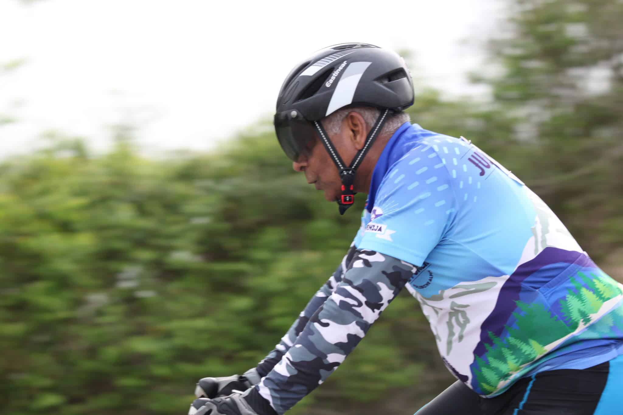 High-performance cyclist wearing a helmet and colorful cycling jersey, enjoying a ride outdoors.