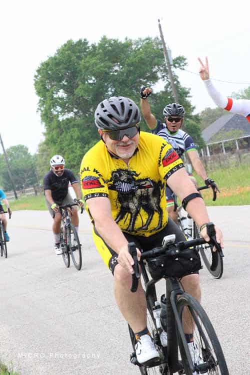 Active cyclists enjoying a group ride on Bluebonnet Express route in scenic Texas countryside.