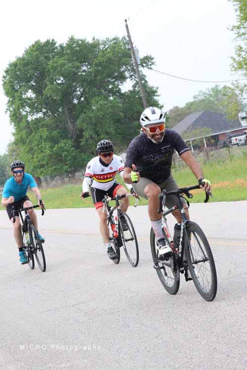 Active cyclists riding together on a scenic road for fitness and outdoor recreation.