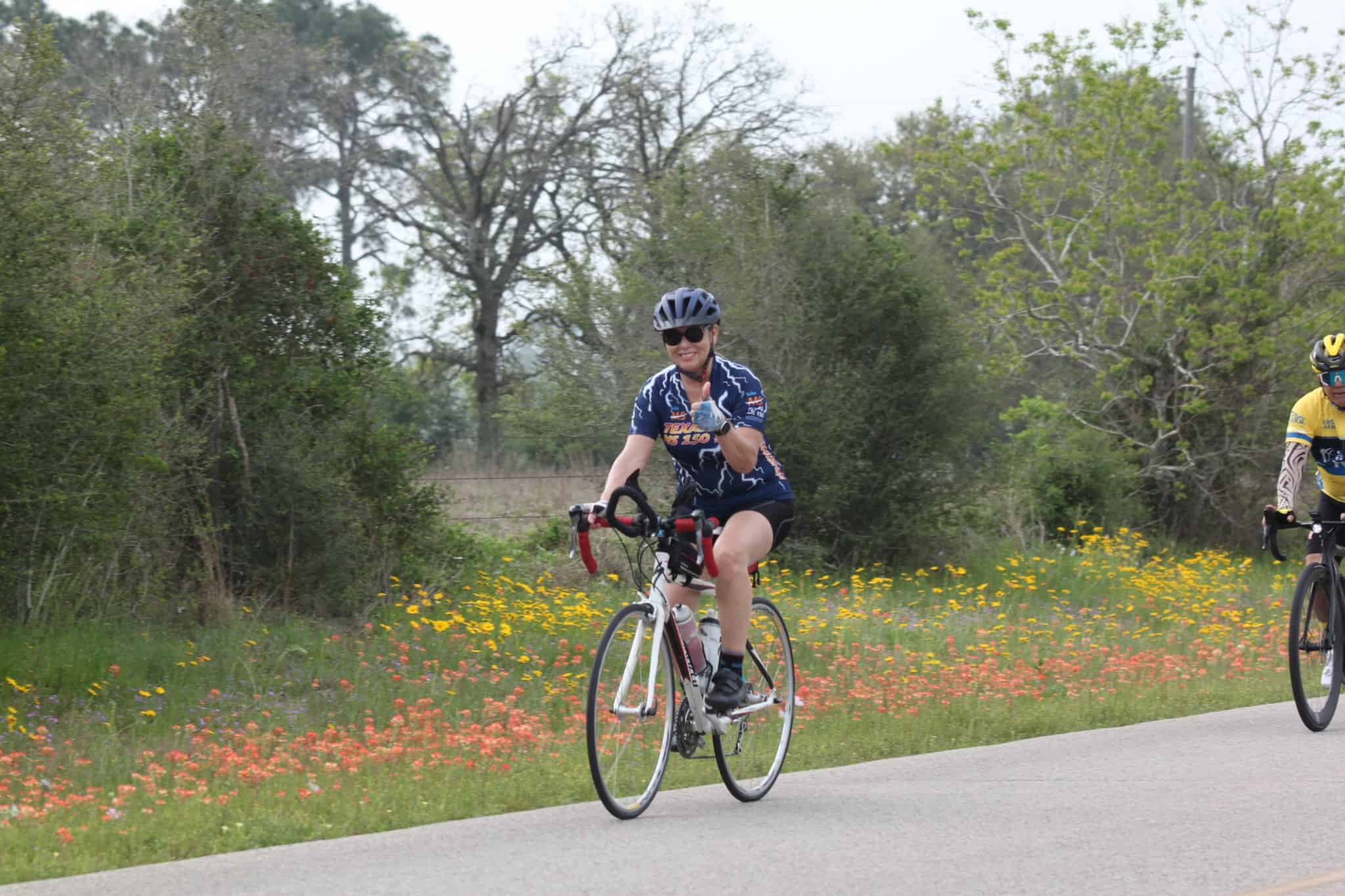 Vibrant cycling event featuring the Bluebonnet Express with cyclists riding through scenic wildflower fields in spring.