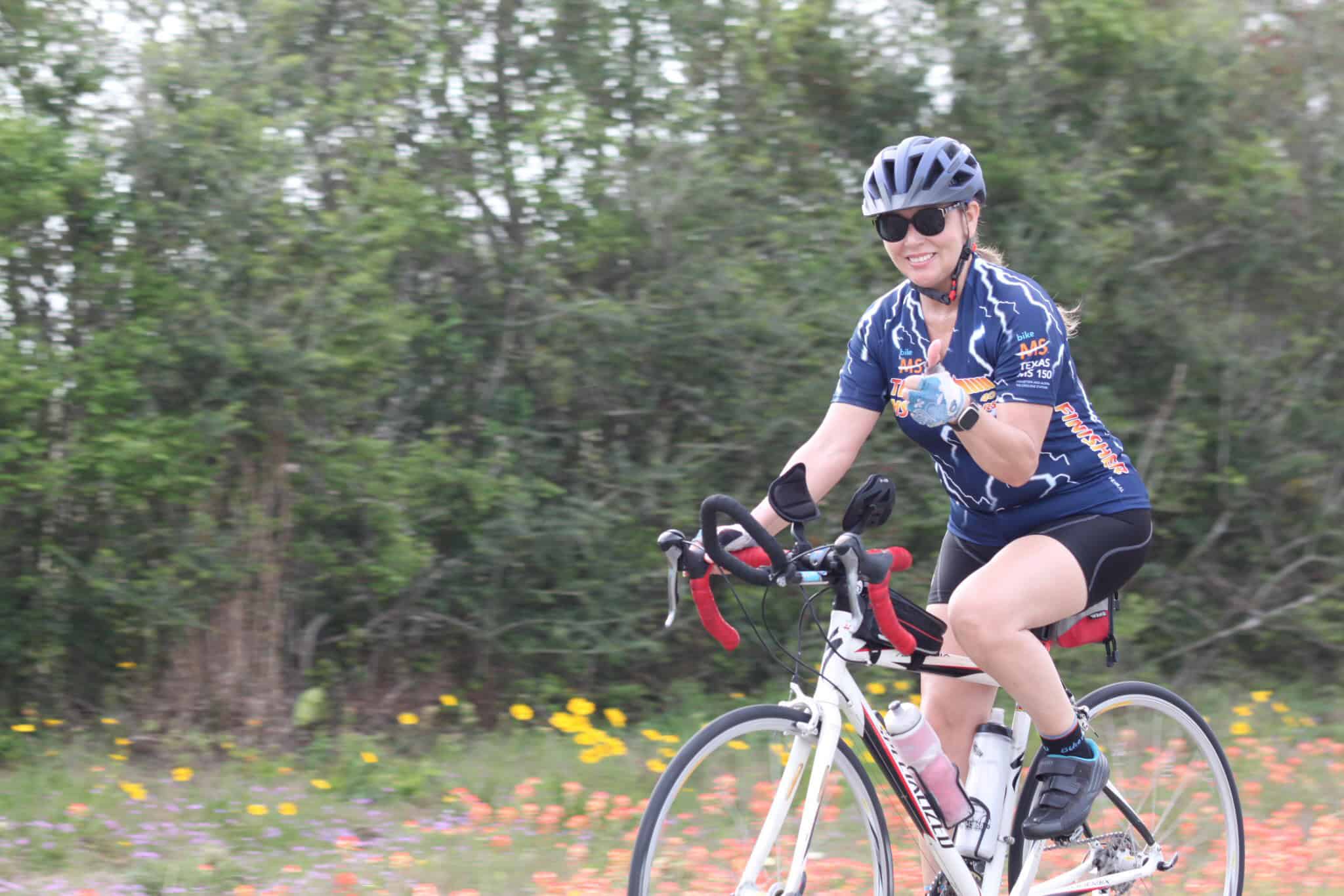 Vibrant cyclist riding through scenic countryside on Bluebonnet Express bike route.