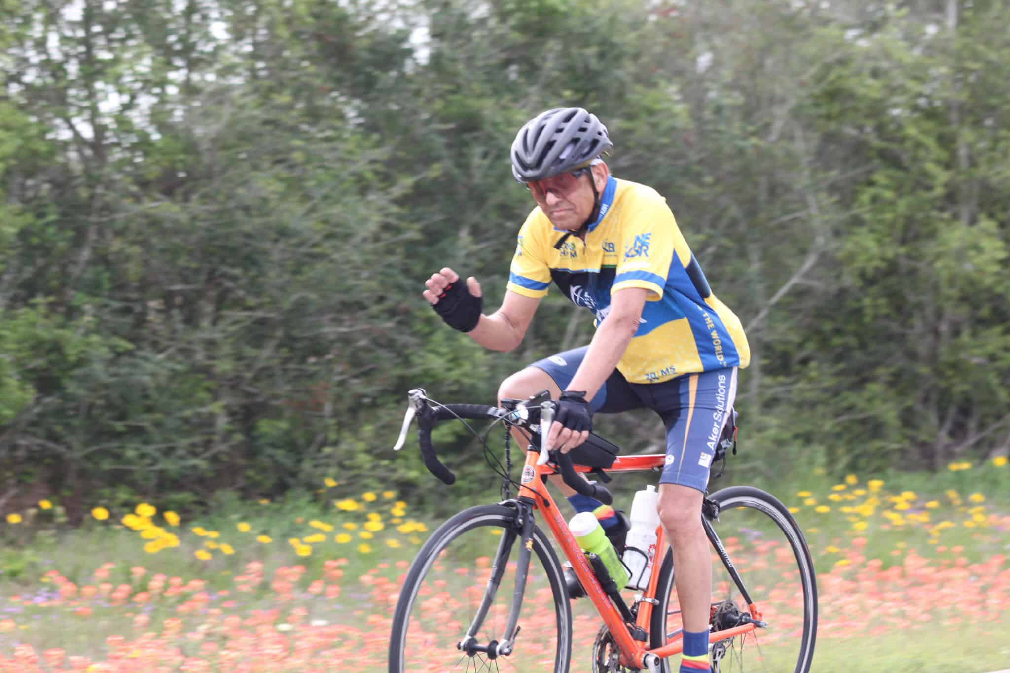 Vibrant cyclist riding on scenic trail with colorful flowers, promoting Bluebonnet Express bike services.