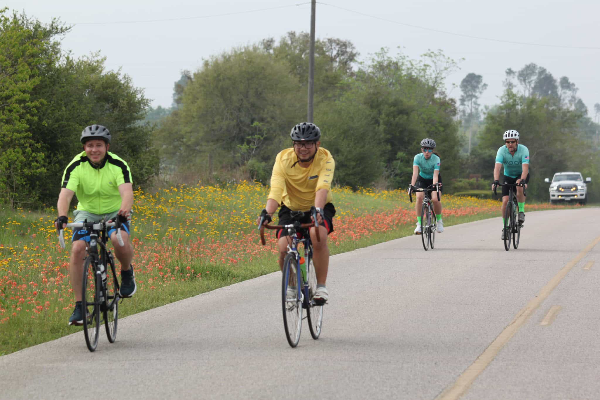 Vibrant group cycling along scenic countryside road on Bluebonnet Express bike route.