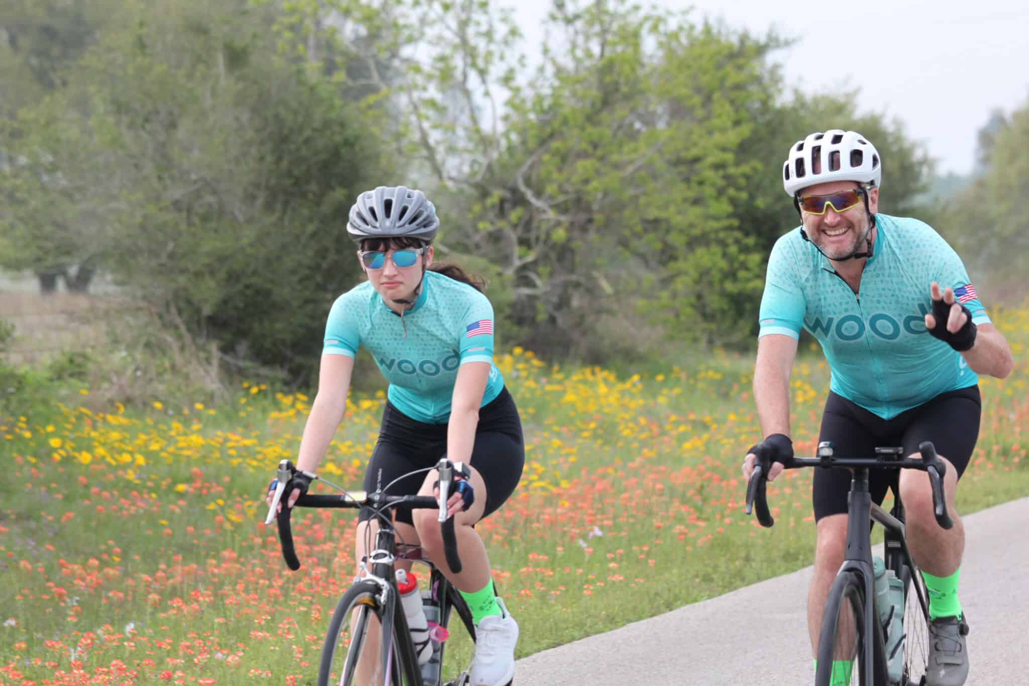 Active cyclists riding through scenic outdoor landscape on bluebonnet express bike ride route.