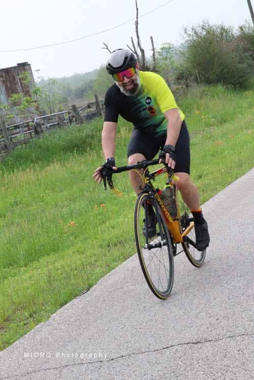 Velo cyclist riding on a scenic trail during daylight, promoting outdoor activity and fitness.