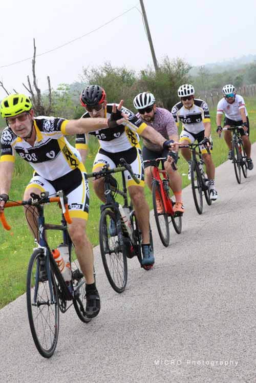 Active cyclist group riding on scenic rural road during Bluebonnet Express event.