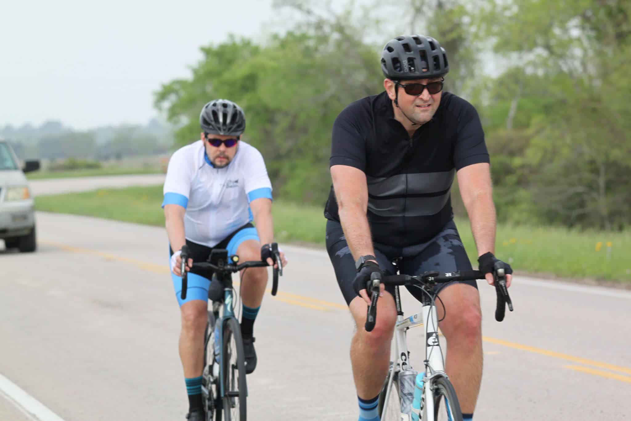 Vibrant Cyclists Riding on Scenic Road in Green Nature.