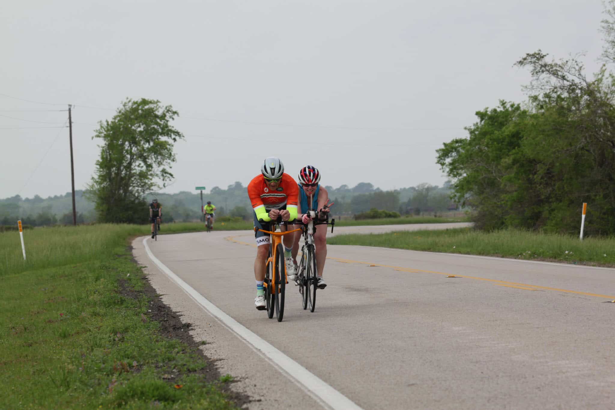 Bike ride on scenic rural road with cyclists in Bluebonnet Express event, promoting cycling and outdoor fitness.
