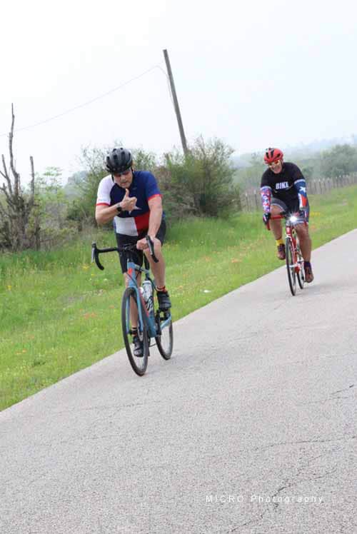 - Cyclists riding on a scenic rural road during a Bluebonnet Express event.